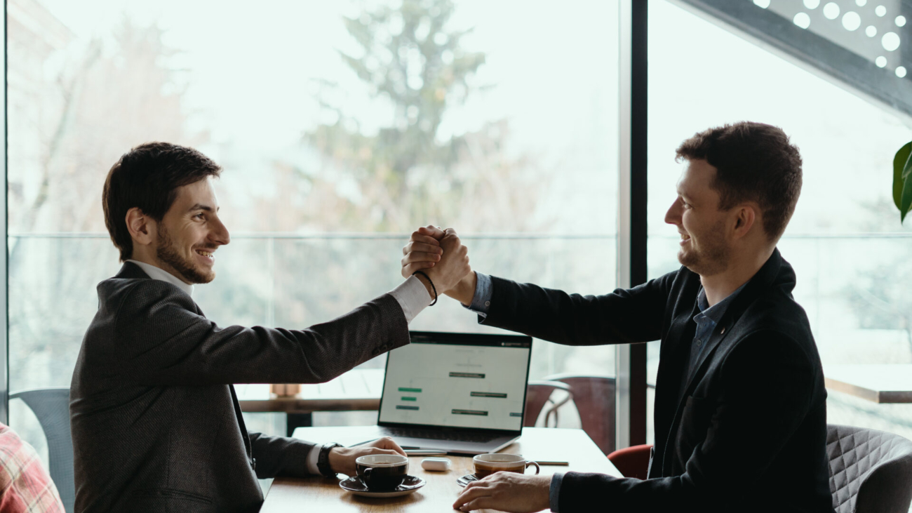 Businessman shaking hand to his partner on meeting, positive management team celebrating victory, successful stock deal, sales growth, won good contract, business achievement and teamwork concept